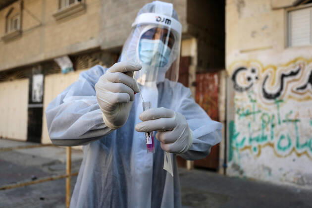 January 11, 2021, Deir Al-Balah, Gaza Strip, Palestinian Territory: A Palestinian medical worker wearing protective gear, takes a random swab sample for COVID-19 testing inside a mosque, in Deir al-Balah, central of Gaza Strip, on January 11, 2021. The Palestinian Authority (PA) has said it expects to receive its first COVID-19 vaccine doses in March under a deal with British drug giant AstraZeneca, and accused Israel of ignoring its responsibilities to ensure vaccines are available in occupied territory Deir Al-Balah Palestinian Territory - ZUMAap3_ 20210111_zaf_ap3_053 Copyright: xAshrafxAmrax