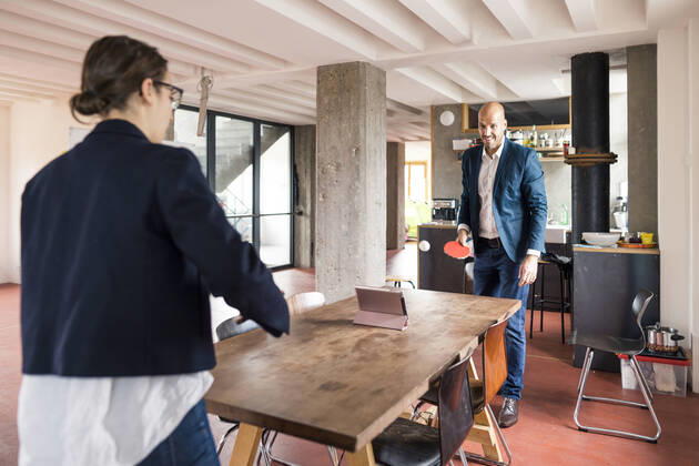 Man and woman playing while standing by table at cafeteria in office model released Symbolfoto property released MOEF03506