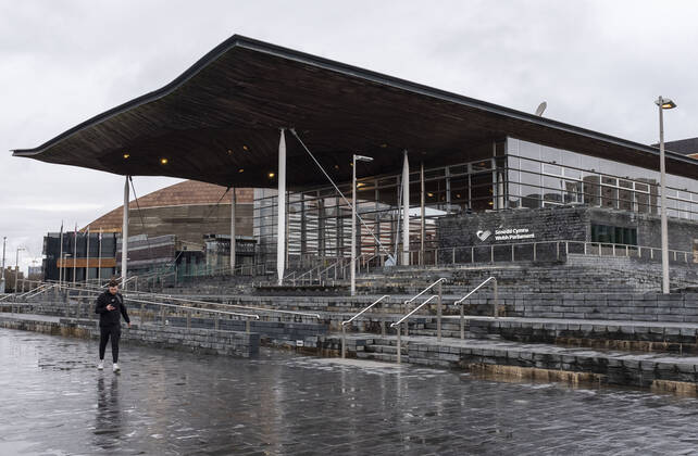 January 12, 2021, Cardiff, Wales, United Kingdom: A man walks past the Wales Parliament (Senedd Cymru) at Cardiff Bay in Wales..1,332 new cases of the coronavirus have been recorded today bringing the total to 172,879 since the pandemic began. The overall death total now stands at 3,997 in Wales. The infection rate is now 403.5 cases per 100,000 people based on the seven days up to January 7. That is down on the 415 previously reported. Cardiff United Kingdom - ZUMAs197 20210112_zab_s197_017 Copyright: xMayxJamesx