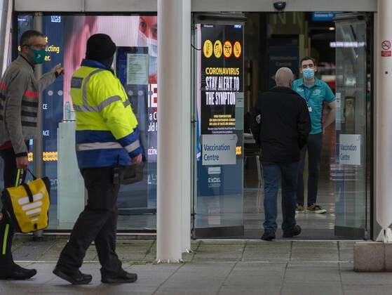 (210113) -- LONDON, Jan. 13, 2021 -- People walk into the Vaccination Centre at ExCel exhibition centre in London, Britain, on Jan. 12, 2021. British Prime Minister Boris Johnson on Monday warned against false complacency as the country is seeking to speed up the coronavirus vaccine rollout. According to the prime minister, 2.4 million coronavirus jabs have been administered across Britain. Seven new mass vaccination sites in England opened Monday, as the country races against time to bring the pandemic under control. ) BRITAIN-LONDON-COVID-19-VACCINE ROLLOUT HanxYan 