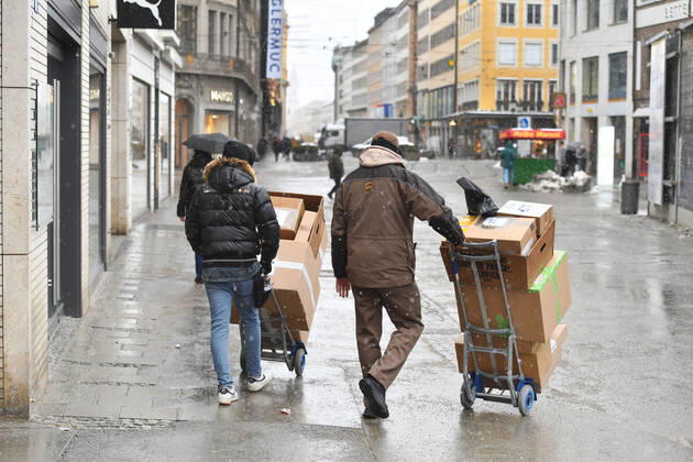UPS parcel delivery driver at work,parcel carrier,United Parcel in downtown in munich delivery in downtown,pedestrian zone in munich on 12 01 2021 service,parcel,parcel service,deliver,unload,send,transporter,hand truck