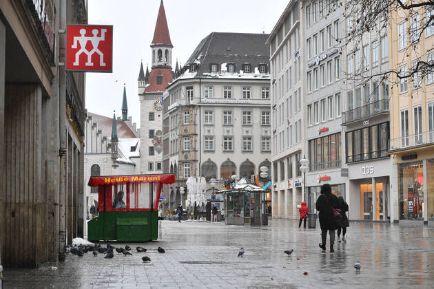 Theme picture Winter in the Coronavirus Pandemic Prolongation Lockdown until 31 January 2021 Empty streets and squares Only a few passers-by go over the Marienplatz in Munich on 12 01 2021 At a hot chestnut stand pigeons cavort persons, passers-by