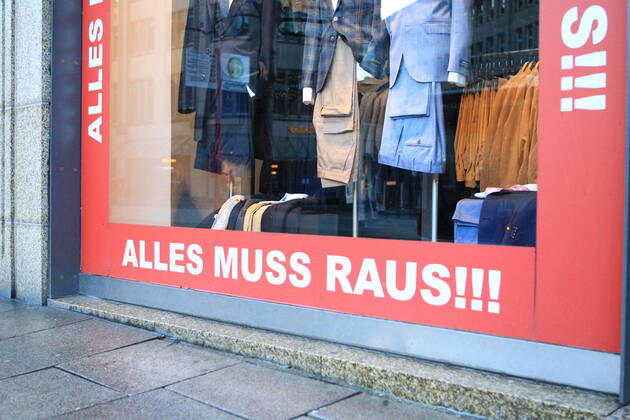 On the window of a closed shop in Hamburgs city centre, a notice is displayed indicating a clearance sale due to the closure of the business Altstadt Hamburg
