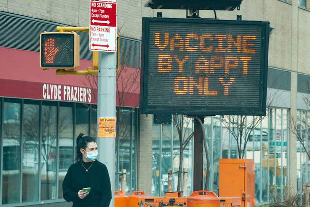 January 13, 2021, New York, New York, USA: A woman walks past a sign as the New York State opens a mass vaccination site at the Jacob Javits Convention Center on Manhattan s West Side on January 13, 2021 in New York. New York USA - ZUMAb148 20210113_zap_b148_005 Copyright: xBryanxSmithx