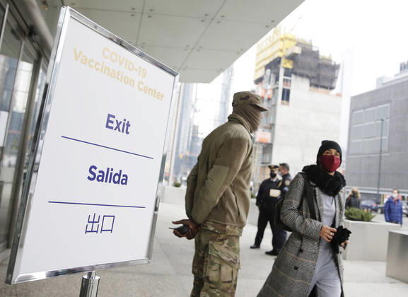 Signs for COVID-19 Vaccintaion are set up outside as patients arrive and go through the check in process to received a COVID-19 vaccination at the Jacob K. Javits Convention Center in New York City on Wednesday, January 13, 2021. The Javits Convention Center which served as a massive field hospital last spring when New York City was the epicenter of the pandemic, now will serve as a huge vaccine distribution center.  NYP20210113120 JohnxAngelillo