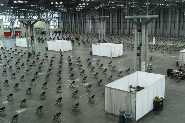 NY: Opening of mass vaccination site at Jacob Javits Center General view of vaccination area including waiting area for medical evaluation inside of Jacob Javits Center on the opening day of vaccination site. Inside that area desks for administer vaccines have been set as well as some pods for private vaccination of people with disabilities and those who would request it. Health care personnel, medical examiners, funeral workers, coroners, essential workers, police officers, firefighters, people older than 65 and more eligible right now to get vaccination in New York State. New York New York United States Copyright: LevxRadin