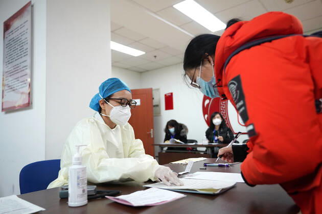(210114) -- BEIJING, Jan. 14, 2021 -- A medical worker (L) explains must-know points to a recipient of COVID-19 vaccine at a temporary inoculation site in Dongcheng District in Beijing, capital of China, Jan. 14, 2021. Beijing is expected to complete administering the first dose of the jab among specific groups of people with higher infection risks by Friday. ) CHINA-BEIJING-COVID-19 VACCINE (CN) JuxHuanzong 