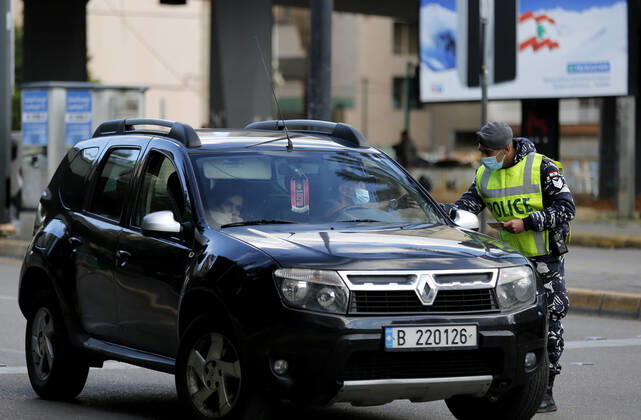 (210115) -- BEIRUT, Jan. 15, 2021 -- A policeman checks a driver s document during a total lockdown in Beirut, Lebanon, on Jan. 15, 2021. Lebanon registered on Friday 6,154 new COVID-19 cases, the highest daily increase in the country, raising the tally to 243,286, the Health Ministry reported. The death toll from the virus went up by 44 to 1,825, it added. ) LEBANON-BEIRUT-COVID-19-CASES BilalxJawich 