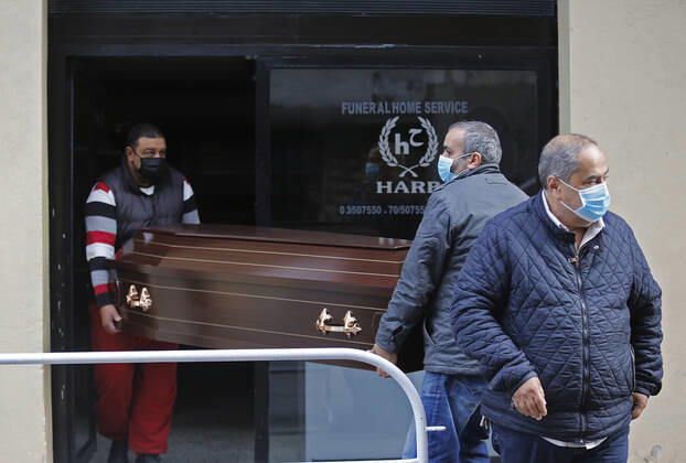 (210115) -- BEIRUT, Jan. 15, 2021 -- Workers of a funeral house carry a coffin during a total lockdown in Beirut, Lebanon, on Jan. 15, 2021. Lebanon registered on Friday 6,154 new COVID-19 cases, the highest daily increase in the country, raising the tally to 243,286, the Health Ministry reported. The death toll from the virus went up by 44 to 1,825, it added. ) LEBANON-BEIRUT-COVID-19-CASES BilalxJawich 