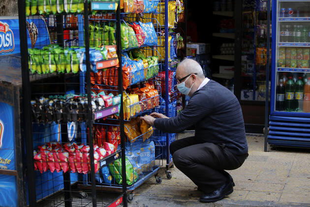 (210115) -- BEIRUT, Jan. 15, 2021 -- A grocer puts items on a shelf during a total lockdown in Beirut, Lebanon, on Jan. 15, 2021. Lebanon registered on Friday 6,154 new COVID-19 cases, the highest daily increase in the country, raising the tally to 243,286, the Health Ministry reported. The death toll from the virus went up by 44 to 1,825, it added. ) LEBANON-BEIRUT-COVID-19-CASES BilalxJawich 