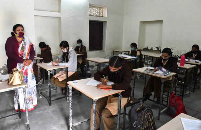 India: Schools reopened after 10 months in Rajasthan A teacher wearing face mask takes the class of students at a government school that was reopened after remaining closed for 309 days due to COVID-19 pandemic in Beawar. Beawar Rajasthan India Copyright: SumitxSaraswat