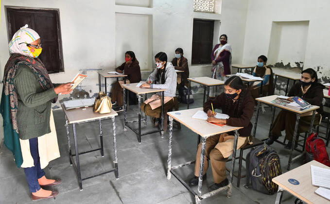 India: Schools reopened after 10 months in Rajasthan A teacher wearing face mask takes the class of students at a government school that was reopened after remaining closed for 309 days due to COVID-19 pandemic in Beawar. Beawar Rajasthan India Copyright: SumitxSaraswat