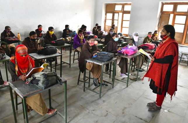 India: Schools reopened after 10 months in Rajasthan A teacher wearing face mask takes the class of students at a government school that was reopened after remaining closed for 309 days due to COVID-19 pandemic in Beawar. Beawar Rajasthan India Copyright: SumitxSaraswat
