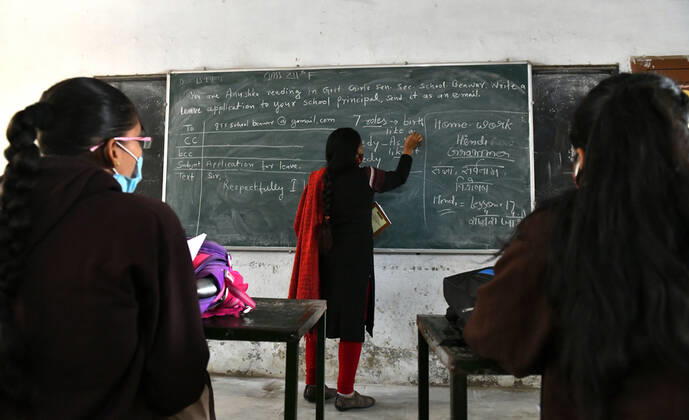 India: Schools reopened after 10 months in Rajasthan A teacher wearing face mask takes the class of students at a government school that was reopened after remaining closed for 309 days due to COVID-19 pandemic in Beawar. Beawar Rajasthan India Copyright: SumitxSaraswat
