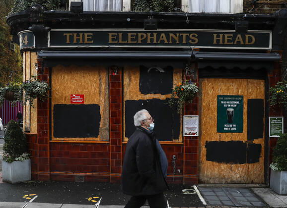 (210120) -- LONDON, Jan. 20, 2021 -- A man wearing a face mask walks past a closed pub in London, Britain, on Jan. 19, 2021. The number of people who have died within 28 days of a positive coronavirus test has surpassed the grim milestone of 90,000 in Britain after another 1,610 were confirmed, according to official figures released Tuesday. The latest daily death toll, the highest since the pandemic began in the country, brought the total number of coronavirus-related deaths in Britain to 91,470, the data showed. ) BRITAIN-LONDON-COVID-19-DEATH TOLL HanxYan