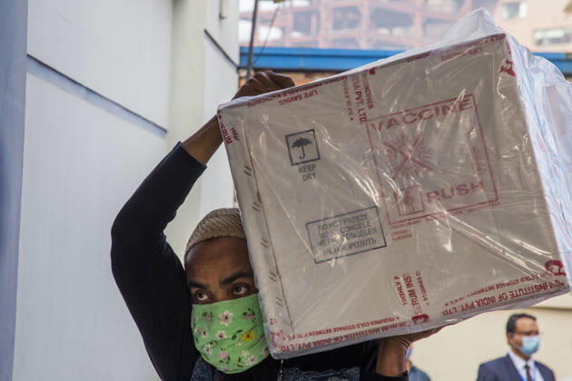 January 21, 2021, Dhaka, Bangladesh: A worker carries a carton of Oxford-AstraZeneca COVID-19 vaccines that arrived from India to Bangladesh as a gift. Dhaka Bangladesh - ZUMAr331 20210121_zip_r331_001 Copyright: xMortuzaxRashedx