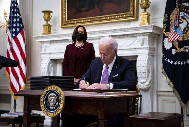 January 21, 2021, Washington, District of Columbia, USA: U.S. President Joe Biden signs an executive order after speaking during an event on his administration s Covid-19 response with U.S. Vice President Kamala Harris, left, in the State Dining Room of the White House in Washington, D.C., U.S., on Thursday, Jan. 21, 2021. Biden in his first full day in office plans to issue a sweeping set of executive orders to tackle the raging Covid-19 pandemic that will rapidly reverse or refashion many of his predecessor s most heavily criticized policies Washington USA - ZUMAs152 20210121_zaa_s152_155 Copyright: xAlxDragox-xPoolxViaxCnpx