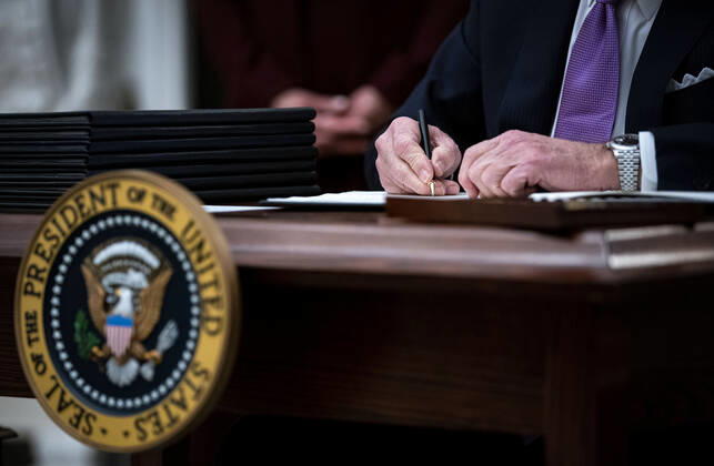U.S. President Joe Biden signs an executive order after speaking during an event on his administration s Covid-19 response in the State Dining Roomof the White House in Washington, D.C., U.S., on Thursday, Jan. 21, 2021. Biden in his first full day in office plans to issue a sweeping set of executive orders to tackle the raging Covid-19 pandemic that will rapidly reverse or refashion many of his predecessor s most heavily criticized policies.  WAXP20210121123 AlxDrago
