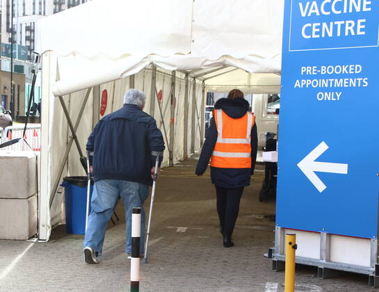 January 21, 2021, London, United Kingdom: An elderly man on crutches walks into the vaccination centre.A steady stream of elderly people with pre-booked appointments at the new Covid-19 Vaccination hub at the Olympic Office Centre, near London s Wembley Stadium. .It is one of 10 new large scale Vaccination centres opened this week, to join the seven already in use across the country. So far 4.9 million people across the UK have received the first dose of vaccine and the government aims for that number to rise to 15 million by 15 February. London United Kingdom - ZUMAs197 20210121_zaa_s197_148 Copyright: xKeithxMayhewx