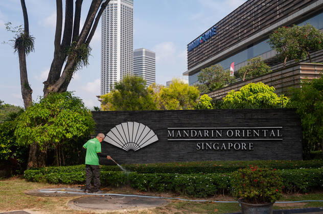 21 01 2021, Singapore, Republic of Singapore, Asia A worker waters plants at the Mandarin Oriental Hotel Singapore in Marina Square Due to the ongoing Corona crisis, many of the city-states hotels are seeing huge revenue losses as h
