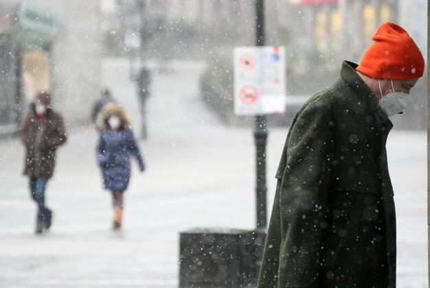 Winter wetter mit Schnee , a men with Safety mask FFP2 is seen under the snow during the Hard Lockdown of the Covid 19 Coronavirus Pandemie in Nuremberg Nurnberg , Bayern , Deutschland . January 24 , 2021.