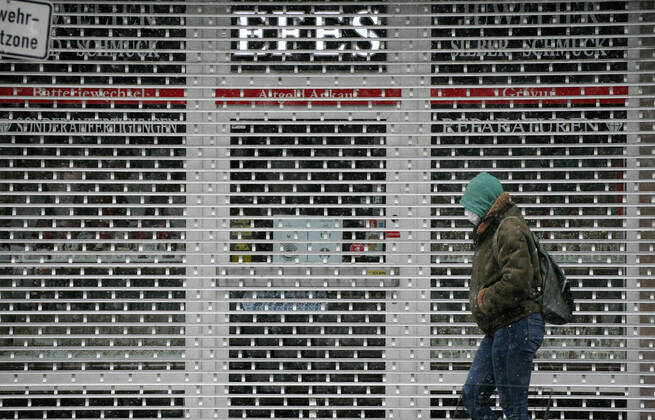 Winter wetter mit Schnee , a women with Safety mask FFP2 is seen under the snow as she walks beside a closed shop during the Hard Lockdown of the Covid 19 Coronavirus Pandemie in Nuremberg Nurnberg , Bayern , Deutschland . January 24 , 2021.