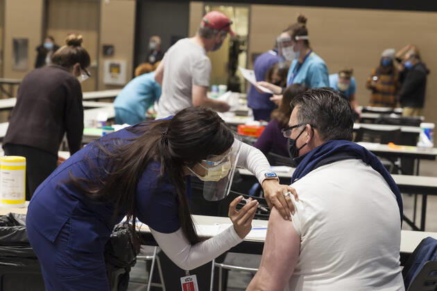 January 24, 2021, Seattle, Washington, U.S: MARYAM MALLICK with Virginia Mason gives an injection to a patient at a pop up COVID-19 vaccine clinic at the Amazon Headquarters in Seattle on Sunday, January 24, 2021. Amazon partnered with Virginia Mason Franciscan Health to vaccinate 2,000 Washingtonians who currently qualify to be vaccinated under the stateÃ¢â‚¬â ¢s COVID-19 Vaccine Phases guidelines. Seattle U.S. - ZUMAg235 20210124_zap_g235_005 Copyright: xPaulxChristianxGordonx