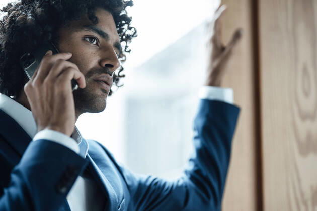 Young male professional talking on mobile phone at office model released Symbolfoto property released JOSEF03013