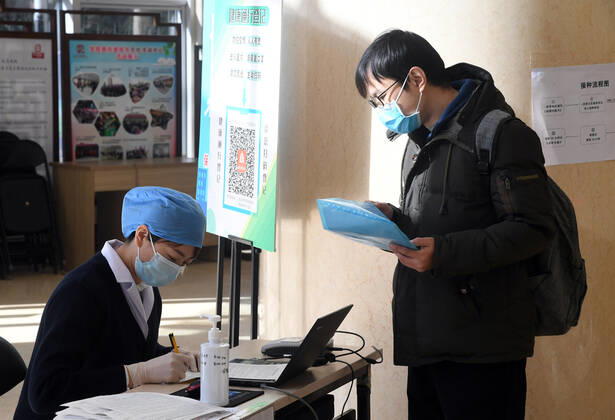 (210129) -- BEIJING, Jan. 29, 2021 -- A medical worker (L) registers recipient information before the COVID-19 vaccination at a temporary vaccination site in Haidian District of Beijing, capital of China, Jan. 29, 2021. The administration of the second dose of COVID-19 vaccines for key groups of residents throughout Beijing started on Jan. 22, and is expected to conclude before Feb. 8. ) CHINA-BEIJING-COVID-19-VACCINATION-2ND-DOSE (CN) RenxChao 