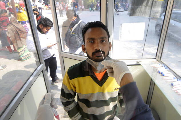 NOIDA, INDIA - FEBRUARY 1: A health worker collects a swab sample from a man for Covid-19 test, at Sector 30 District Hospital, on February 1, 2021 in Noida, India. (Photo by Sunil Ghosh Hindustan Times) Daily Life Amid Covid-19 Pandemic In India