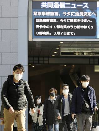Japan to extend virus emergency to March 7 as hospitals strained People wearing face masks walk in front of JR Osaka Station on Feb. 2, 2021. The Japanese government is set to extend a coronavirus state of emergency for Tokyo, Osaka and other regions by one month to March 7 in view of manpower-strapped hospitals amid a surge in serious patients. 