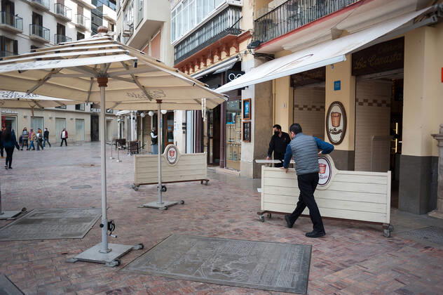 February 3, 2021, Malaga, Spain: Workers seen lifting boards to close a coffee shop at an empty Plaza de la constitucion square amid the partial lockdown caused by coronavirus pandemic. Malaga Spain - ZUMAs197 20210203_zab_s197_019 Copyright: xJesusxMeridax