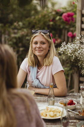 IMAGO Creative: Landleben - Essen IMAGO Creative: Landleben - Alfresco, Draußen Smiling teenage girl sitting with food at table during dinner party Sweden, Gothenburg, model released, property released Copyright: xMaskotx , MA83779