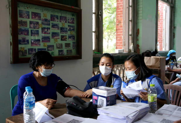 (210205) -- YANGON, Feb. 5, 2021 -- Medical workers check the physical condition of a woman before she receives the COVID-19 vaccine at a school in Yangon, Myanmar, Feb. 5, 2021. Myanmar resumed the vaccination program against COVID-19 across the country on Friday, according to an announcement from the Health and Sports Ministry. (Photo by Xinhua) MYANMAR-VACCINATION-COVID-19-RESUMPTION Haymhan 