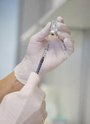 Pulling the syringe out of the bottle with vaccine Bavarian Vaccination Center Augsburg, press tour Bavarian Vaccination Center Augsburg, press tour