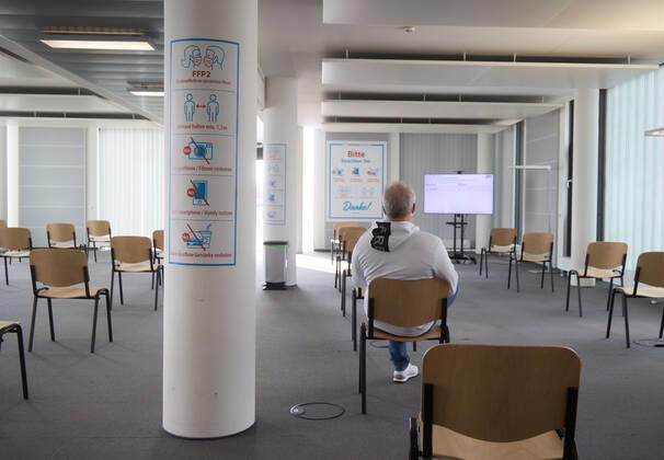 Follow-up area, a vaccinated person sitting on a chair during a 15-minute rest period Bavarian Vaccination Center Augsburg, press tour Bavarian Vaccination Center Augsburg, press tour