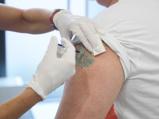 Vaccination of a middle-aged man, vaccination takes place in an unstained spot in a tattoo, Bavarian Vaccination Center Augsburg, press tour Bavarian Vaccination Center Augsburg, press tour