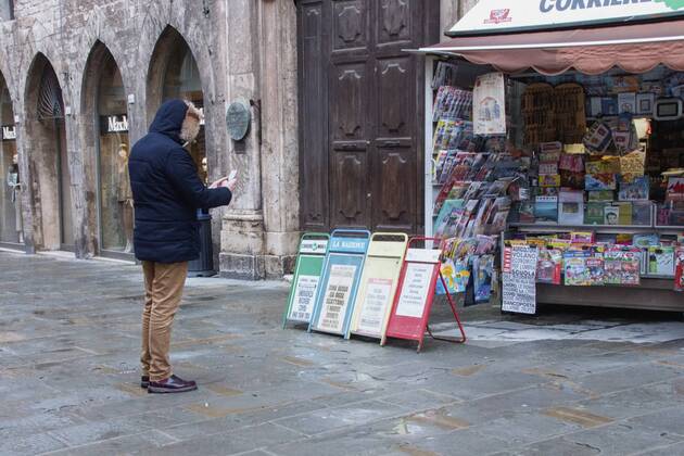 Perugia in the red zone. The capital and the province in full state of emergency covid 19 also due to the variants of the virus present in the area. the city is back in full lockdown. the deserted historic center. anguish and fear reign. one of the two newsstands in the historic center, a gentleman stops to photograph the crocodiles. Editorial Usage Only  Copyright: xEmanuelaxBinconix xIPAx