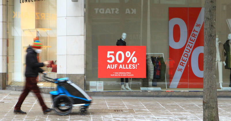 In the window of a retail store closed during the lockdown is a sticker indicating discount promotions Downtown Hamburg