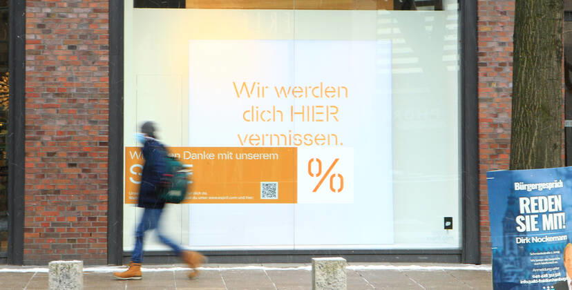 In the window of a retail store closed during the lockdown is a sticker indicating discount promotions Downtown Hamburg