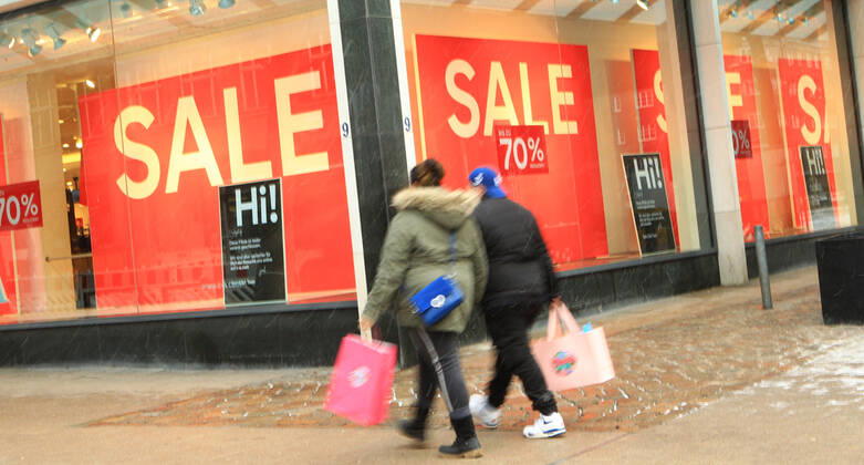 In the window of a retail store closed during the lockdown is a sticker indicating discount promotions Downtown Hamburg