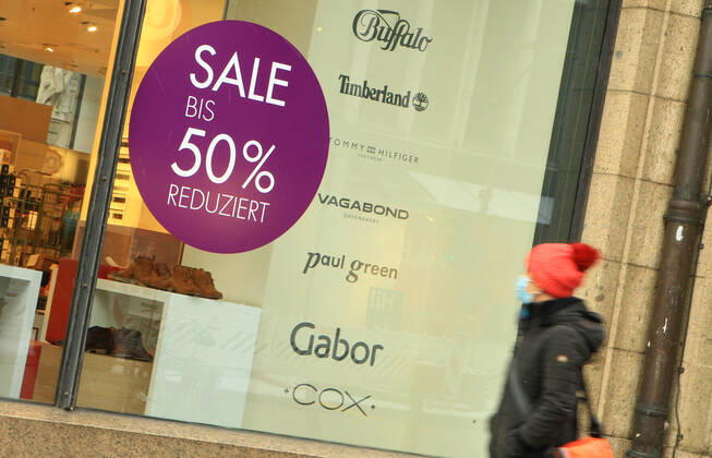 In the window of a retail store closed during the lockdown is a sticker indicating discount promotions Downtown Hamburg