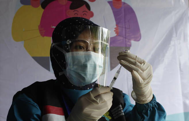 Indonesia s COVID-19 Mass Vaccination A health worker prepares a SinoVac COVID-19 vaccine during a mass vaccination for medical workers and elderly people in Bogor, West Java on February 11, 2021. (Photo by Adrian INA Photo Agency) 