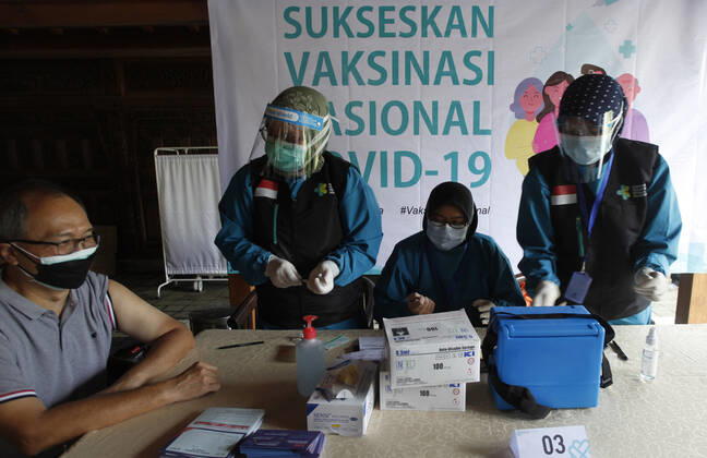 Indonesia s COVID-19 Mass Vaccination A health worker vaccinates elderly health workers during COVID-19 mass vaccination for medical workers and elderly people in Bogor, West Java on February 11, 2021. (Photo by Adrian INA Photo Agency) 