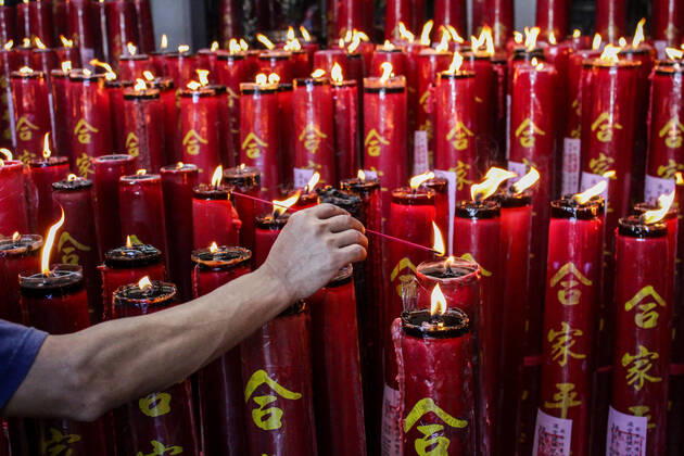 February 12, 2021, Bandung, West Java, Indonesia: A man lights candles at the Dharma Ramsi Temple during the Lunar New Year celebrations..The Lunar New Year, also known as Spring Festival, falls on 12 February 2021, marking the beginning of the Year of the Ox. Bandung Indonesia - ZUMAs197 20210212_zaa_s197_076 Copyright: xAlgixFebrixSugitax