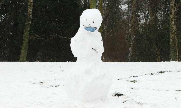 A snowman with a mask stands in the Hamburg city park Winterhude Hamburg
