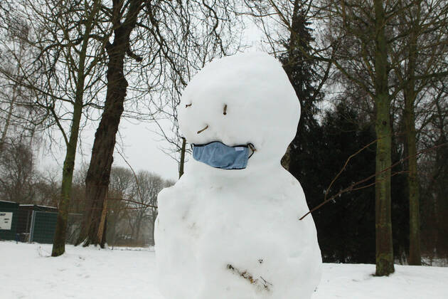 A snowman with a mask stands in the Hamburg city park Winterhude Hamburg