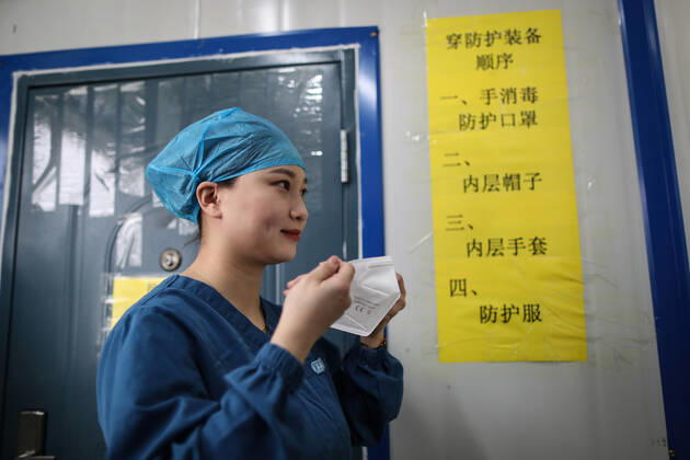 (210216) -- SHENYANG, Feb. 16, 2021 -- Sun Hewen, a medical worker with Shengjing Hospital of China Medical University, puts on a mask in Shenyang, capital of northeast China s Liaoning Province, Feb. 16, 2021. Since December last year, some areas in China s northeastern Heilongjiang, Jilin, and Liaoning Provinces reported newly confirmed COVID-19 cases. Related areas responded immediately according to epidemic prevention requirements. Mass nucleic acid testing were conducted in key areas in an effort to stem the spread of the coronavirus. Recently, no new confirmed COVID-19 cases have been reported here for several days. During the Spring Festival vacation, many workers stick to their posts to make sure we can celebrate the festival safel