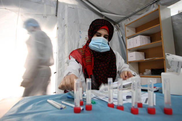 A Palestinian paramedic wearing a full protective suit, organizes COVID-19 tests on Tuesday, February 16, 2021 in Khan Yunis, southern Gaza. The Palestinian Authority claims that Israel is stopping delivery of COVID-19 vaccines into Gaza, from the West Bank.  GAZ2021021614 IsmaelxMohamad