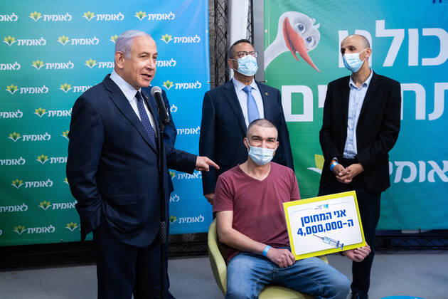 Coronavirus in Israel, Benjamin Netanyahu während Pressetermins zur 4-Milionsten Impfung Israeli Prime Minister Netanyahu (L) poses with Israel s 4,000,000th covid vaccination recipient at the Leumit Health Care Services vaccination facility in Jerusalem in Israel on Tuesday, February 16, 2021. Pool photo by Alex Kolomoisky  JERX20210216206 ALEXxKOLOMOISKY